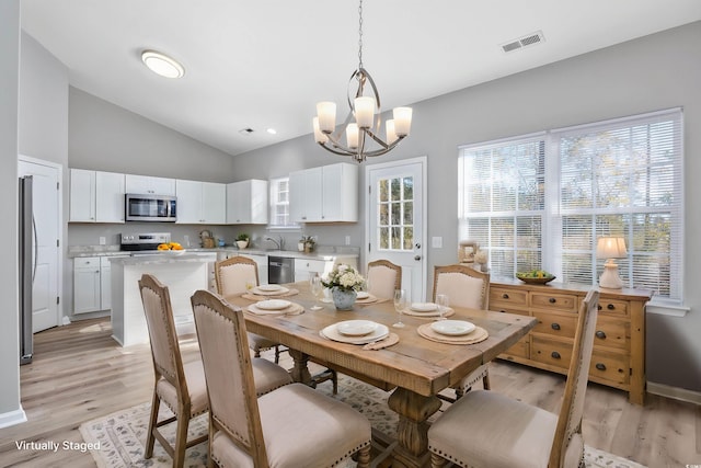 dining space featuring lofted ceiling, visible vents, an inviting chandelier, baseboards, and light wood-style floors