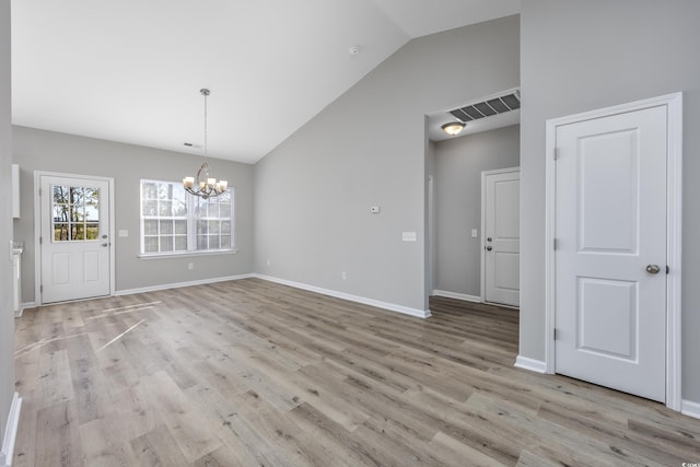 unfurnished dining area featuring baseboards, light wood finished floors, visible vents, a chandelier, and vaulted ceiling
