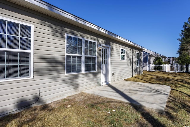 rear view of house featuring a patio and fence