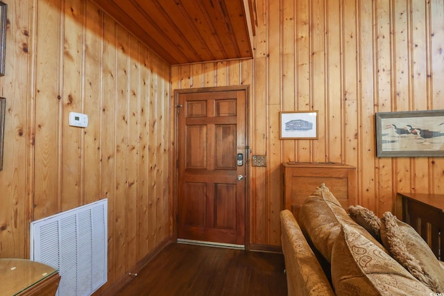 entryway with visible vents, wood walls, wood ceiling, and dark wood finished floors