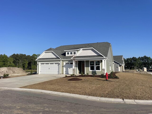 view of front of house with an attached garage, a shingled roof, and concrete driveway