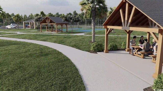 view of home's community with a gazebo, a tennis court, fence, and a lawn