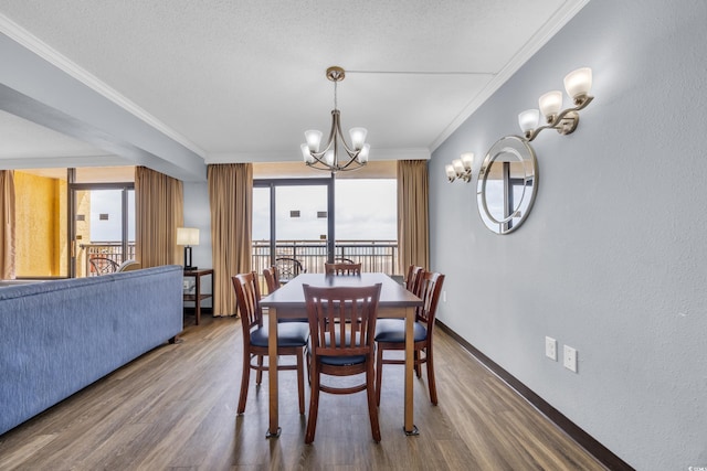 dining area featuring wood finished floors, a chandelier, ornamental molding, and baseboards