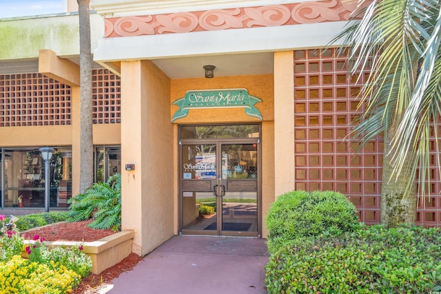 entrance to property featuring stucco siding and french doors