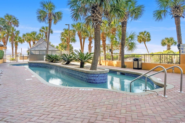 view of swimming pool with fence and a patio