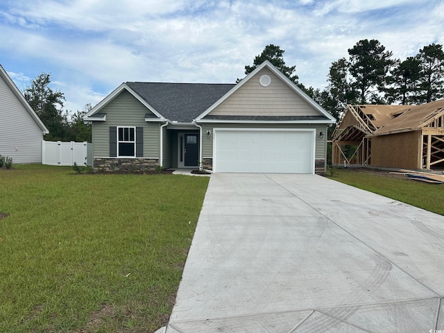 view of front facade with a garage, driveway, stone siding, a gate, and roof with shingles