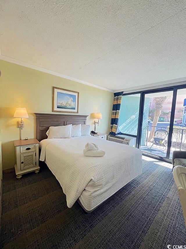 2311 S Ocean Blvd Unit 144, Myrtle Beach, SC 29577 - bedroom with a textured ceiling, access to outside, ornamental molding, and dark colored carpet