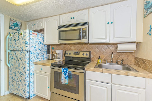200 76th Ave N Unit 1211, Myrtle Beach, SC 29572 - kitchen featuring stainless steel appliances, a sink, white cabinetry, light countertops, and a textured ceiling