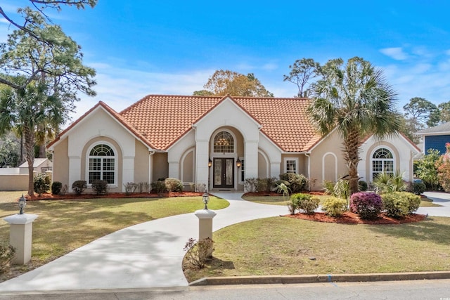 5628 Marion Cir, Myrtle Beach, SC 29577 - mediterranean / spanish house featuring a tiled roof, stucco siding, french doors, and a front yard