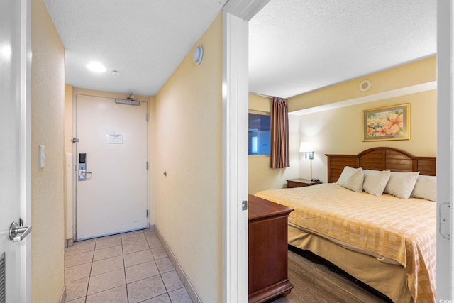 1604 N Ocean Blvd Unit 904, Myrtle Beach, SC 29577 - bedroom with light tile patterned flooring, baseboards, and a textured ceiling