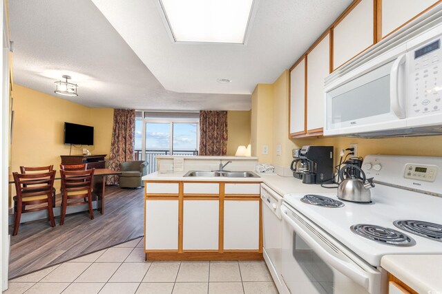 1604 N Ocean Blvd Unit 904, Myrtle Beach, SC 29577 - kitchen featuring open floor plan, light countertops, white appliances, light tile patterned floors, and a sink