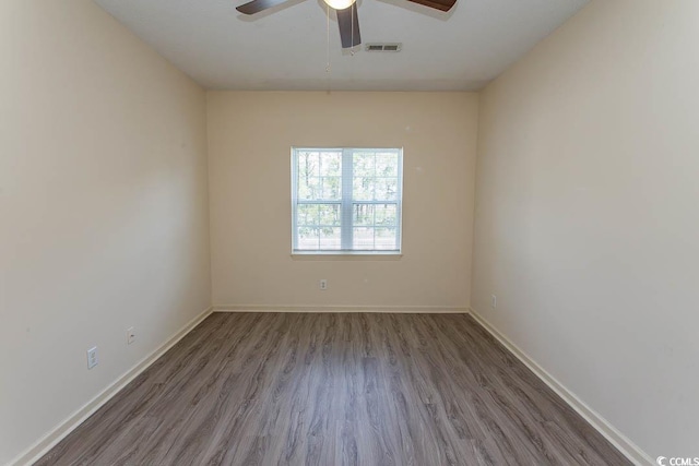 unfurnished room with baseboards, a ceiling fan, wood finished floors, and visible vents