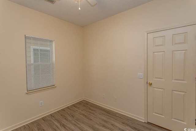 spare room with baseboards, a ceiling fan, and wood finished floors