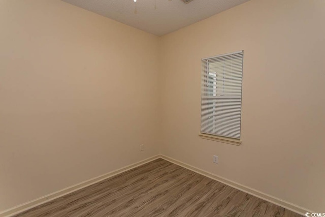 empty room with baseboards and wood finished floors