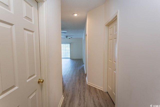 hallway with baseboards, recessed lighting, and wood finished floors