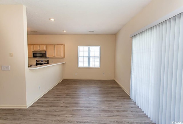 unfurnished living room with light wood-style floors, baseboards, recessed lighting, and visible vents