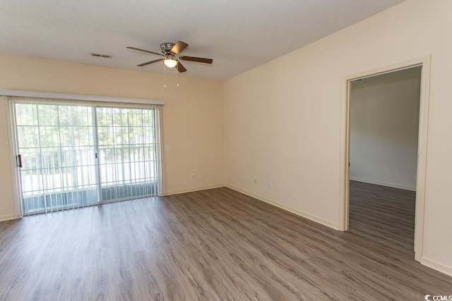 empty room featuring baseboards, a ceiling fan, wood finished floors, and visible vents