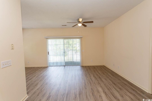 empty room with baseboards, a ceiling fan, and wood finished floors