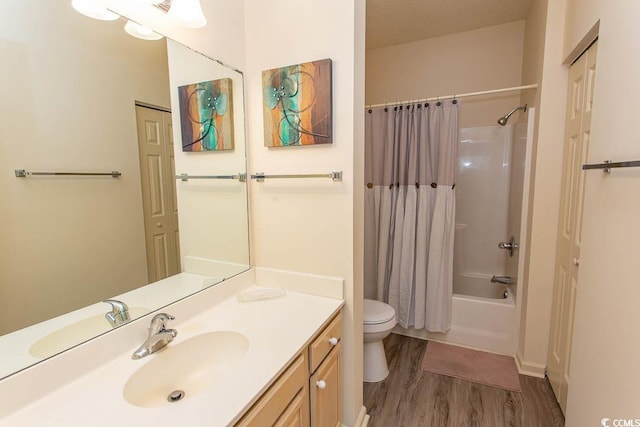 full bath with vanity, wood finished floors, shower / bath combo, and toilet