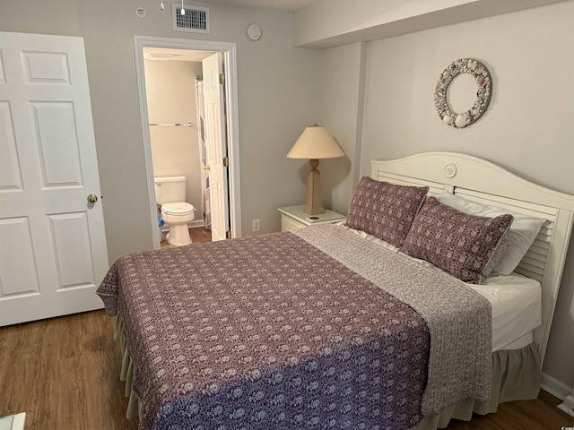 bedroom with wood finished floors, ensuite bathroom, and visible vents