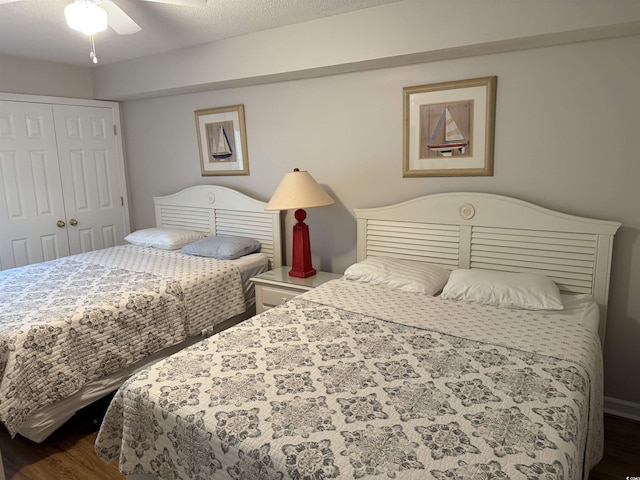 bedroom with dark wood-type flooring, a closet, and a ceiling fan