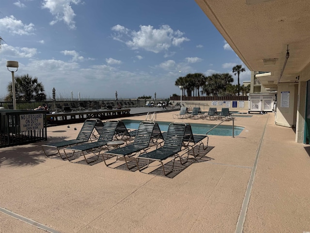 community pool featuring a patio area and fence