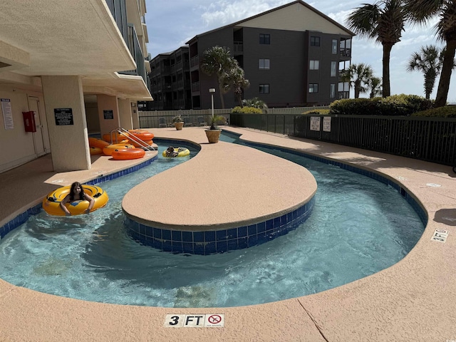 community pool with fence and a patio
