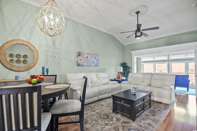 living area with crown molding, lofted ceiling, ceiling fan, a chandelier, and wood finished floors