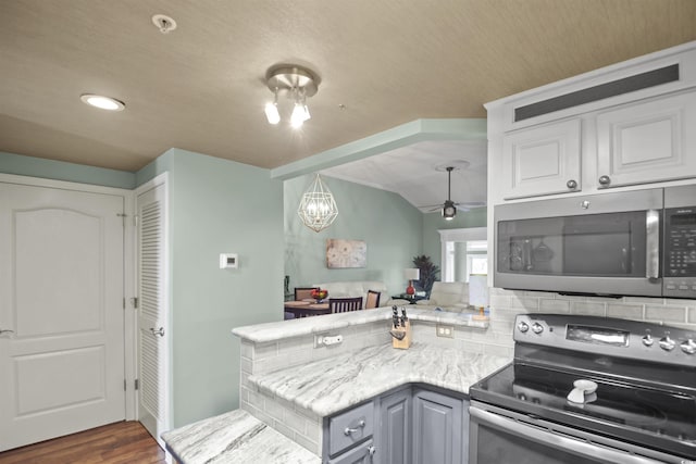 kitchen featuring stainless steel appliances, ceiling fan, a peninsula, dark wood finished floors, and recessed lighting