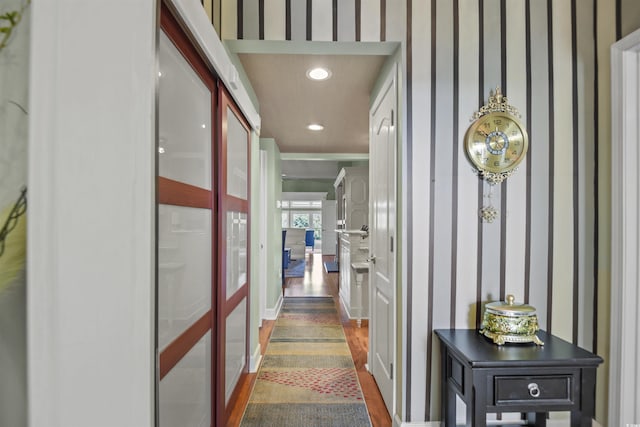 hall with a decorative wall, recessed lighting, and dark wood-style floors