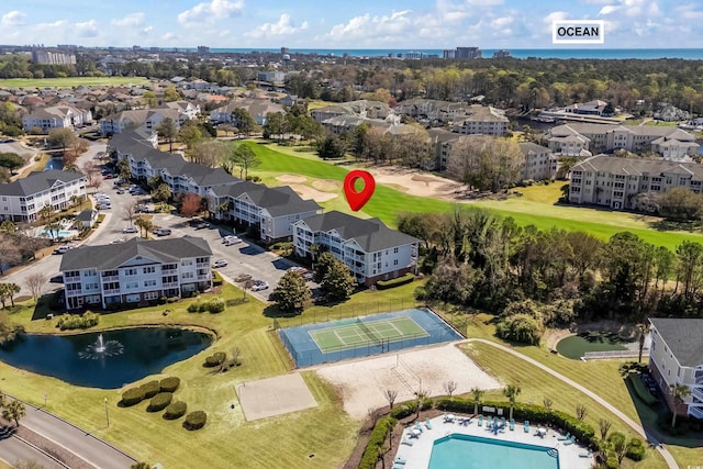 aerial view of a large body of water, a golf course, and a pool area