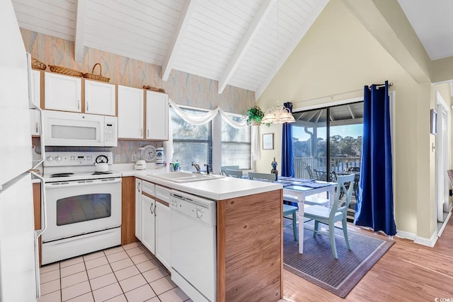 kitchen with a sink, white appliances, light countertops, white cabinetry, and vaulted ceiling with beams