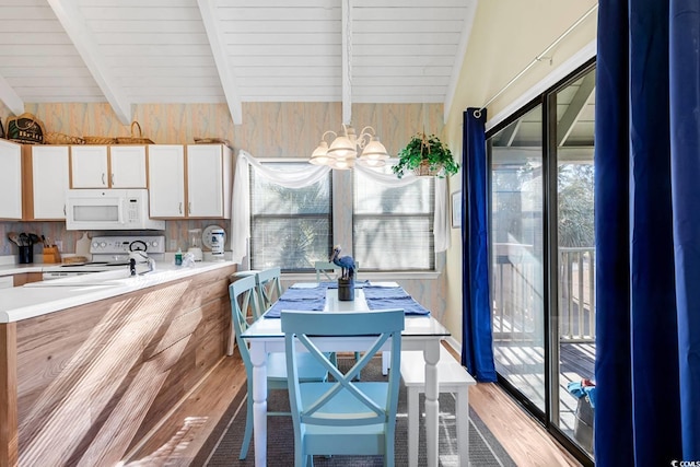 dining room with light wood-type flooring, an inviting chandelier, and beam ceiling