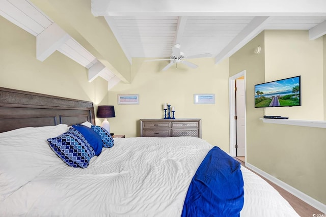 bedroom featuring wood finished floors, ceiling fan, baseboards, and vaulted ceiling with beams