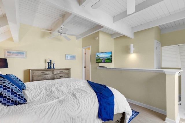 bedroom with baseboards, a ceiling fan, wood finished floors, and lofted ceiling with beams