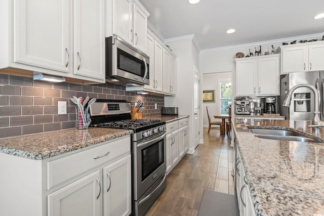 1101 Bronwyn Cir N, Myrtle Beach, SC 29582 - kitchen with stainless steel appliances, a sink, crown molding, white cabinets, and light stone counters