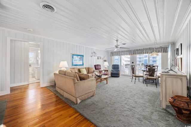 living area with a wealth of natural light, visible vents, and ornamental molding