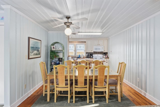 dining space with light wood finished floors, crown molding, baseboards, and a ceiling fan