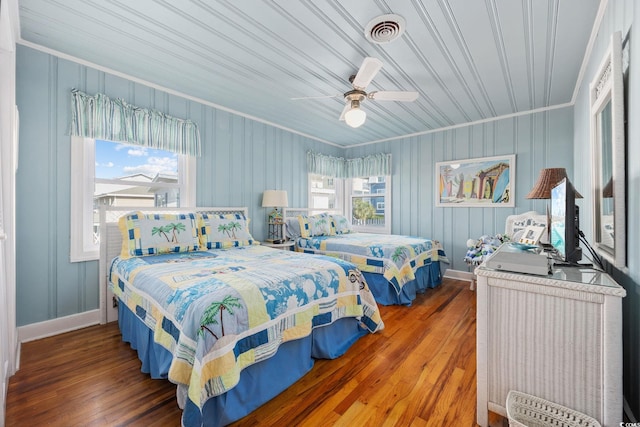 bedroom with a ceiling fan, ornamental molding, hardwood / wood-style floors, and visible vents