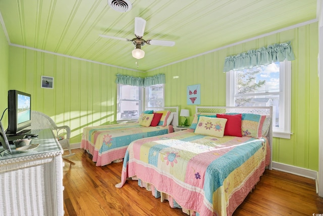 bedroom with visible vents, multiple windows, and wood finished floors