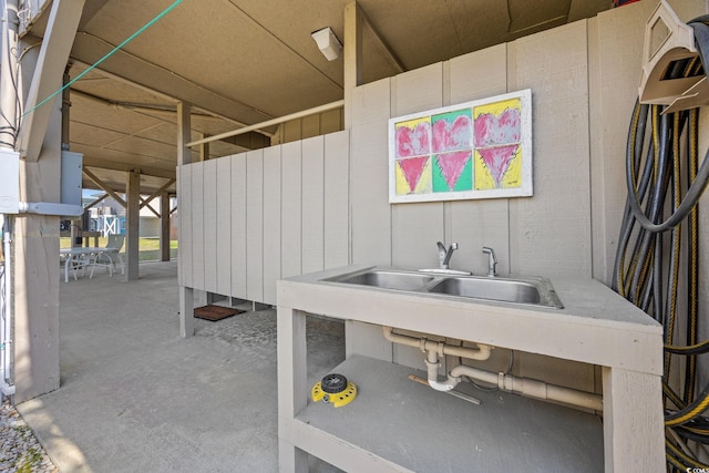 miscellaneous room featuring a sink and unfinished concrete flooring