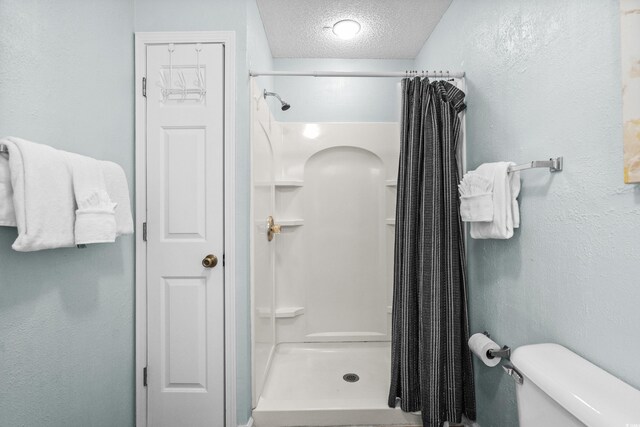 213-A 16th Ave S, Surfside Beach, SC 29575 - full bath featuring toilet, a textured ceiling, and a stall shower