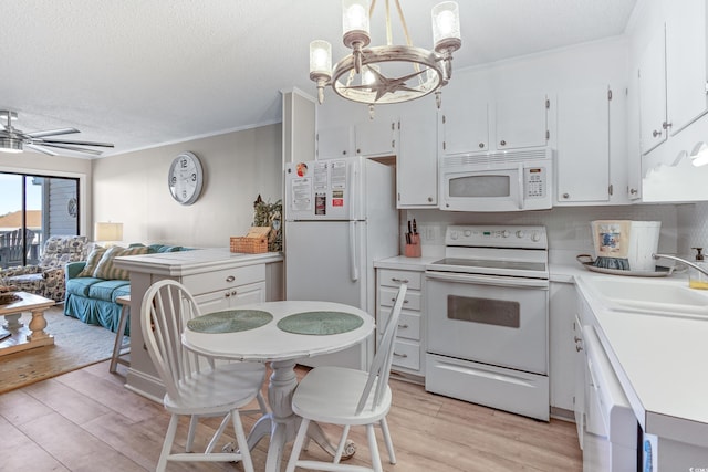 kitchen featuring white appliances, white cabinetry, light countertops, a sink, and light wood finished floors