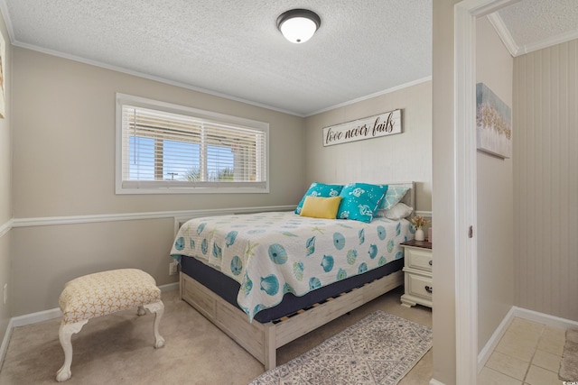 bedroom featuring a textured ceiling, light tile patterned flooring, baseboards, and ornamental molding