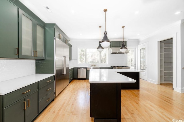 kitchen featuring crown molding, light countertops, a center island, and stainless steel appliances