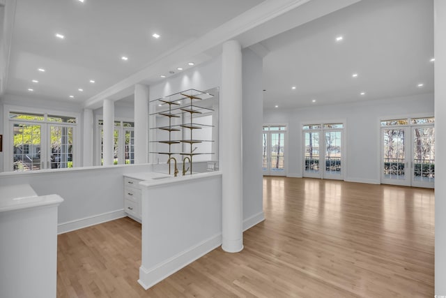 interior space featuring light wood-style floors, french doors, a healthy amount of sunlight, and recessed lighting