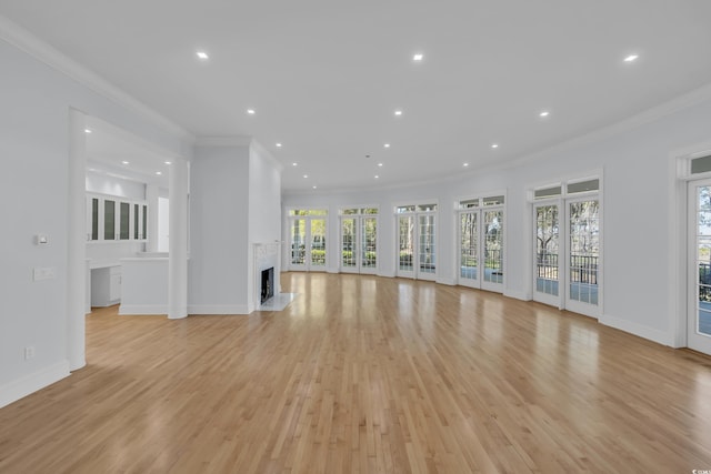 unfurnished living room with baseboards, ornamental molding, a fireplace, recessed lighting, and light wood-style flooring