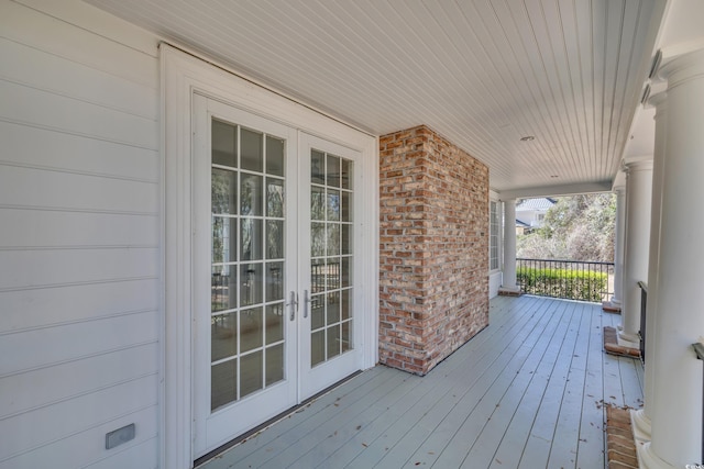 wooden deck featuring a porch and french doors