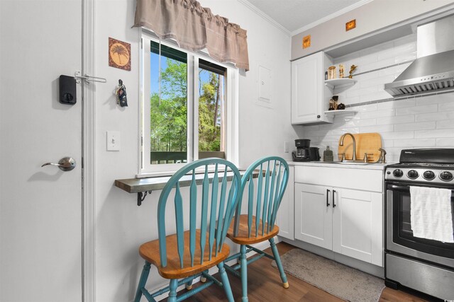 610 Putters Ln Unit H-109, Little River, SC 29566 - kitchen with wood finished floors, stainless steel electric range, wall chimney exhaust hood, tasteful backsplash, and a sink