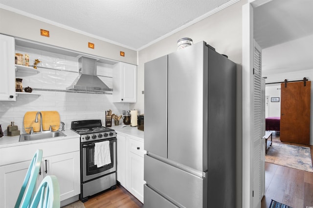 610 Putters Ln Unit H-109, Little River, SC 29566 - kitchen featuring decorative backsplash, wood finished floors, wall chimney range hood, a sink, and appliances with stainless steel finishes